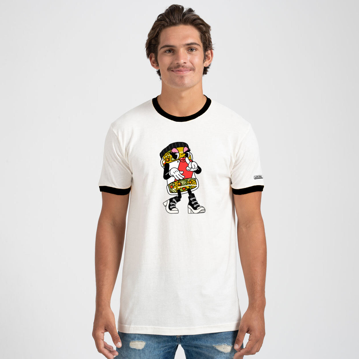 Man wearing a white t-shirt with a cartoon character design on a plain background